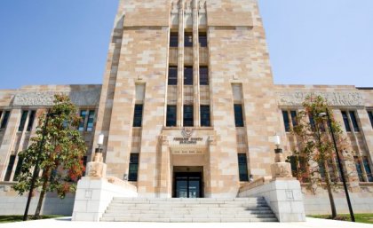 Forgan Smith building, UQ St Lucia campus. A phot of the main entrance to UQ's Forgan Smith sandstone building on a sunny day.